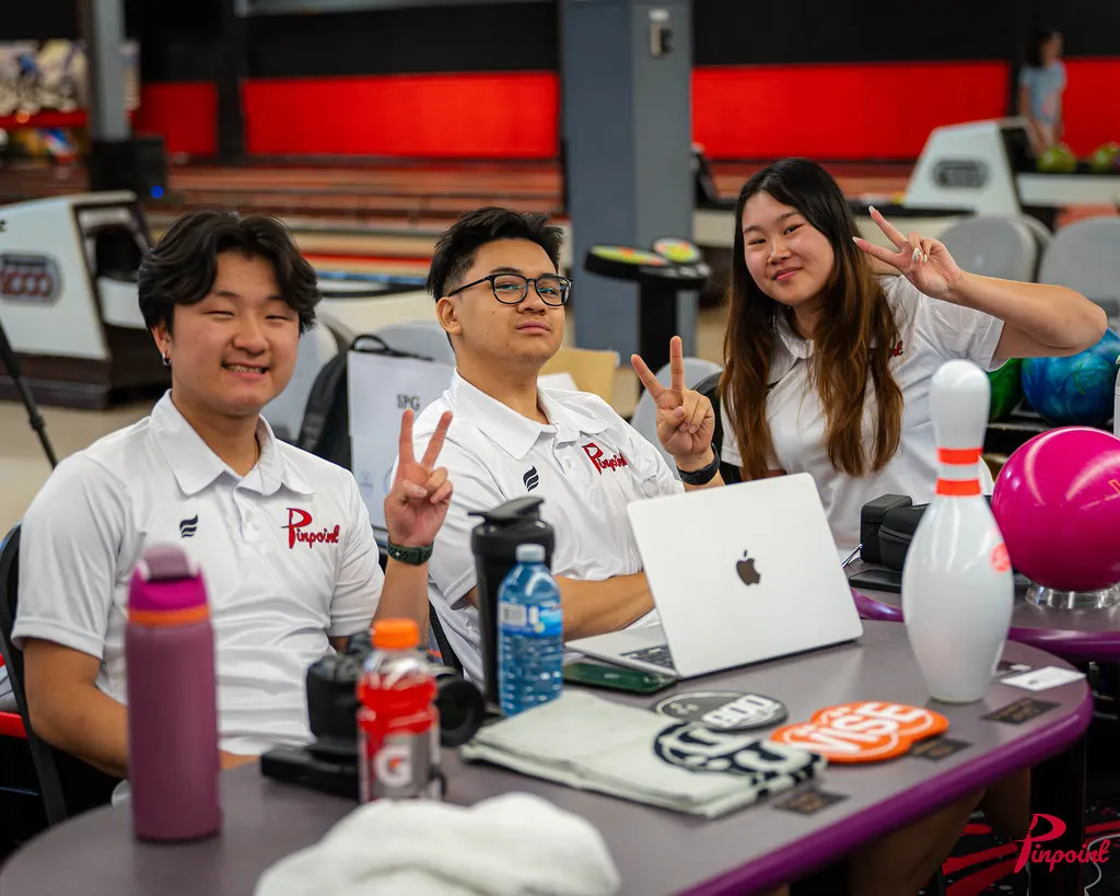 Our event staff throw peace signs at the check-in desk, 2025