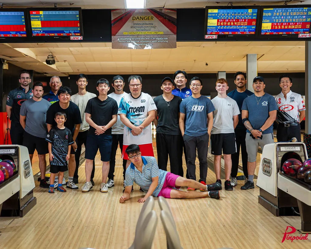 Bowlers and pros line up for a group photo at The Toronto Experience, one lying across the front