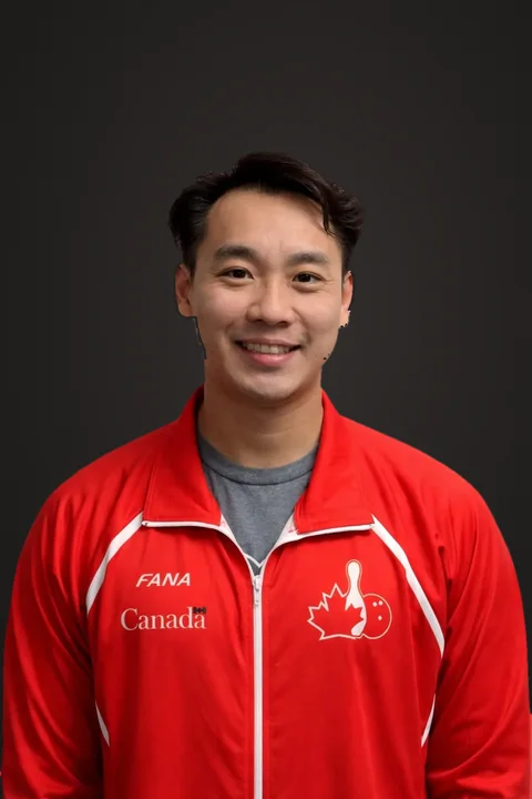Sly Yeung in a red Team Canada jacket, smiling